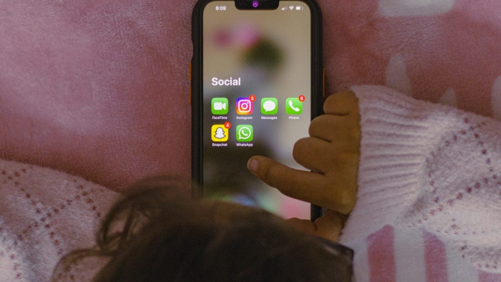 Adolescent utilisant un smartphone pour illustrer le débat français sur l'accès aux réseaux sociaux